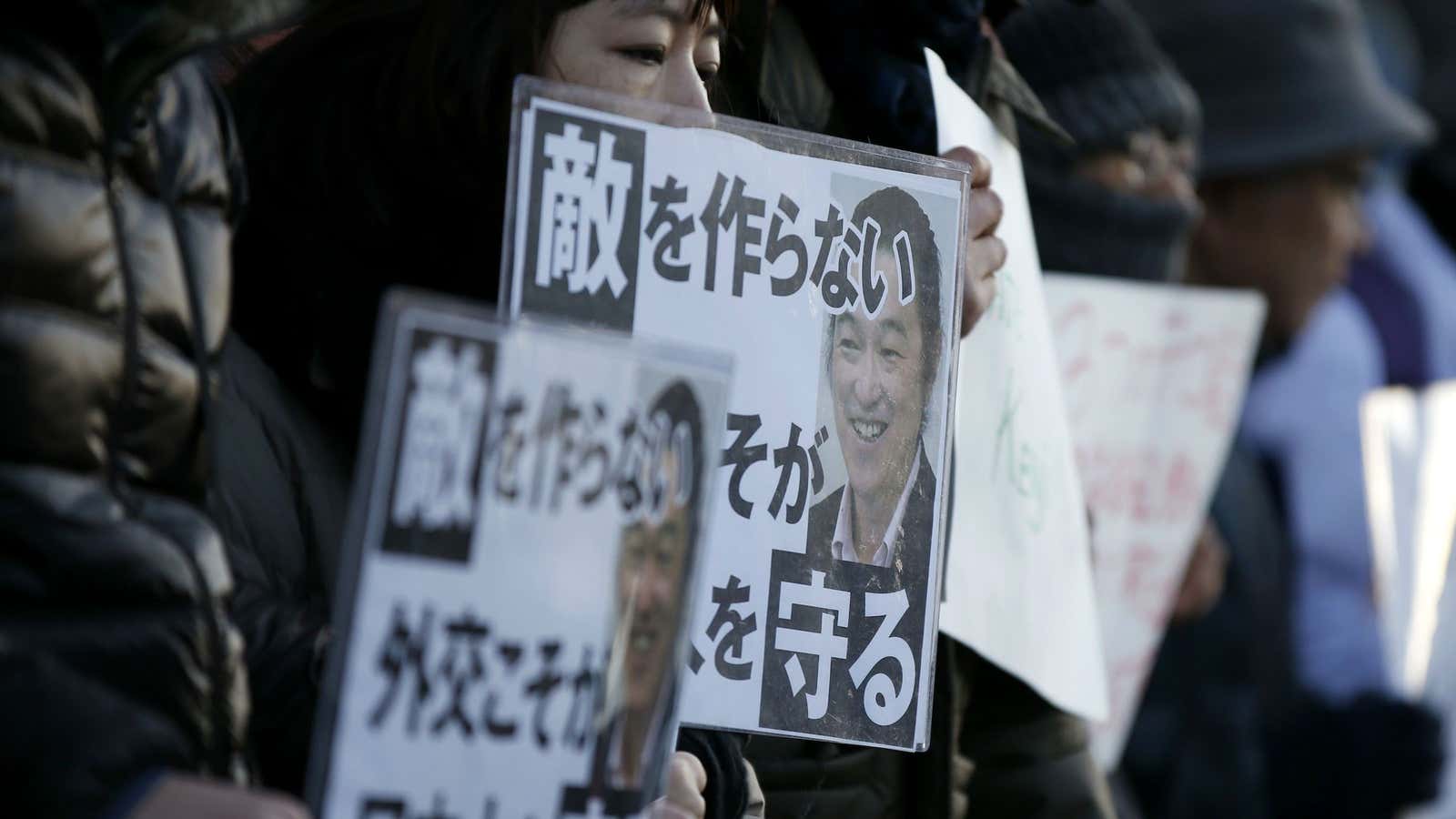 Protesters hold placards that say “Diplomacy not to make an enemy protects a Japanese.”
