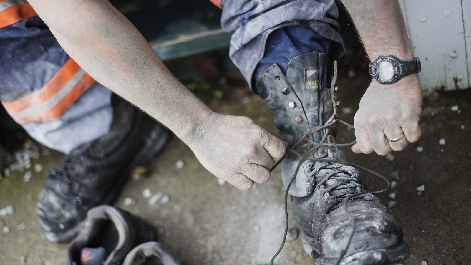 A Kentucky coal miner removes boots covered in toxic coal dust.