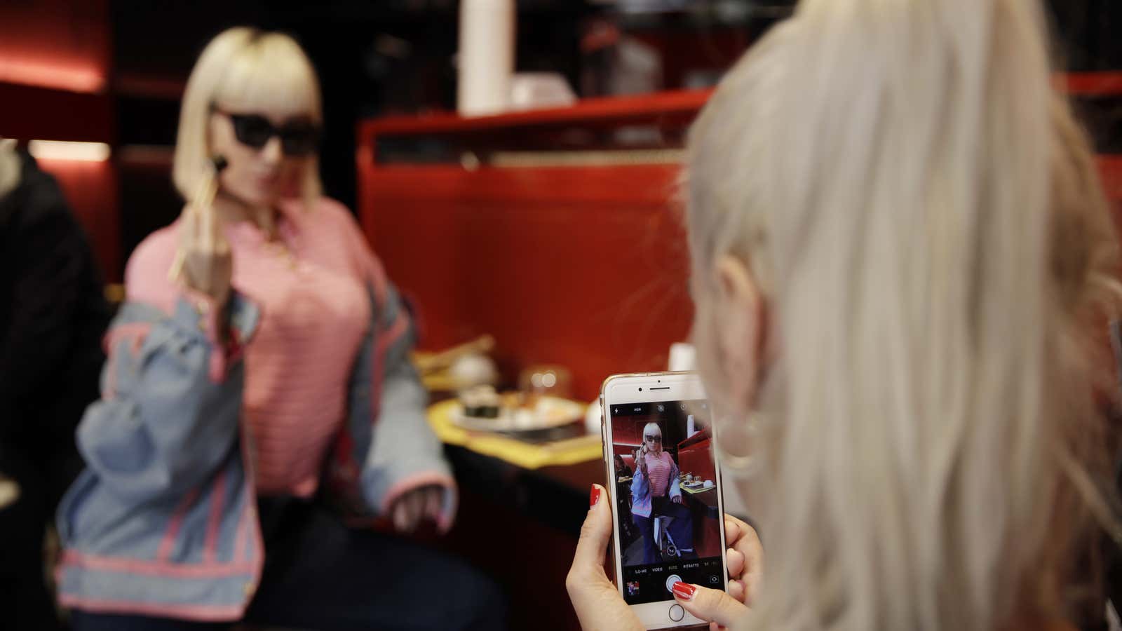 Customer Fashion blogger Clizia Incorvaia, right, takes pictures of her friend singer Vittoria Hyde as they have lunch at the ‘This is not a Sushi…