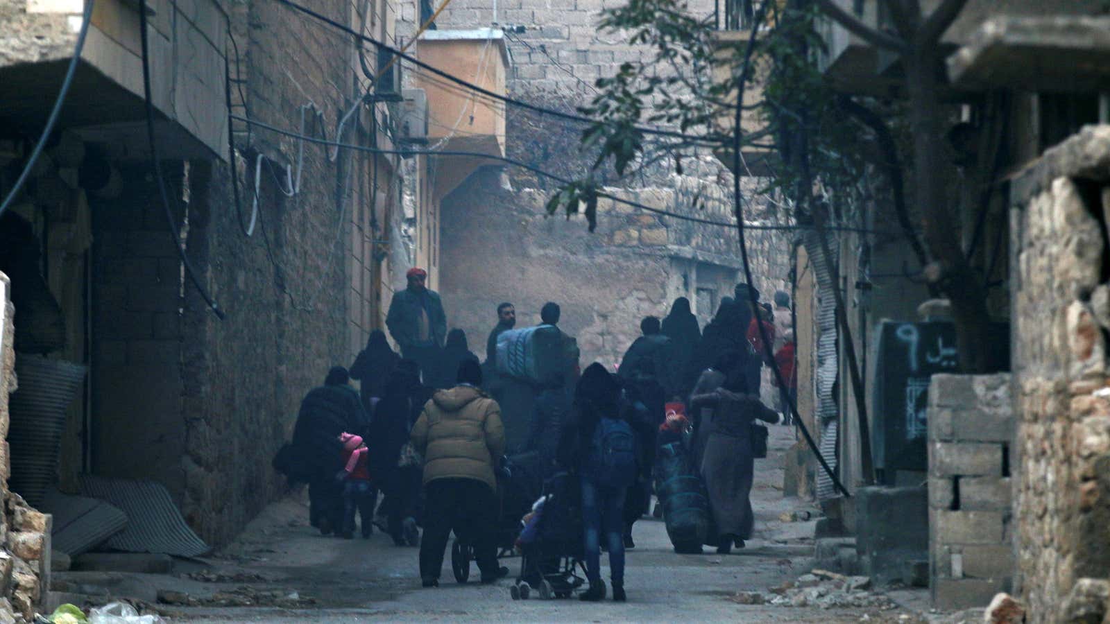 People carry belongings as they flee deeper into the remaining rebel-held areas.