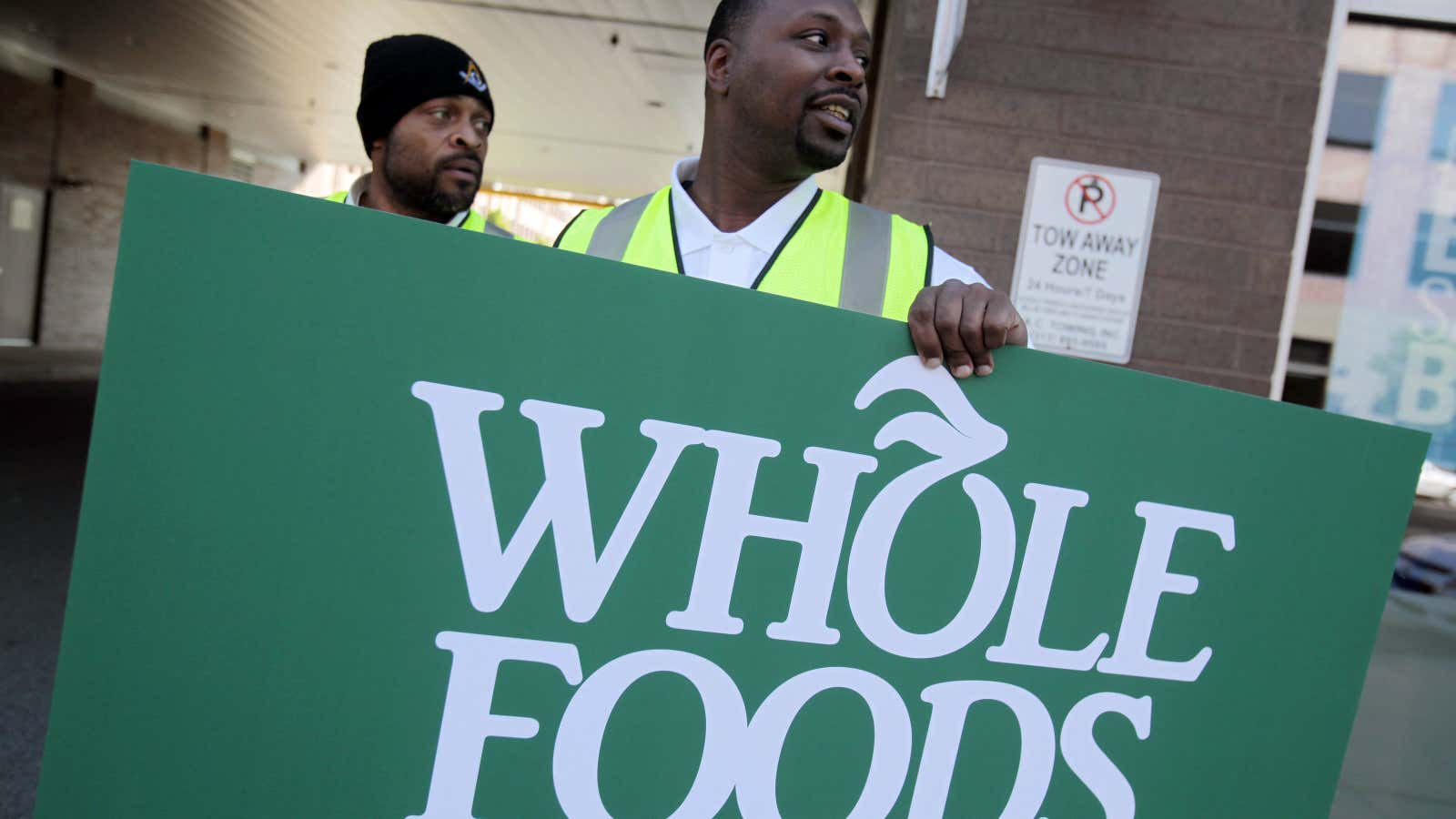 Troy Moss holds a sign as he directs traffic towards parking for the site of a ground breaking ceremony of the new 20,000-square-foot Whole Foods…