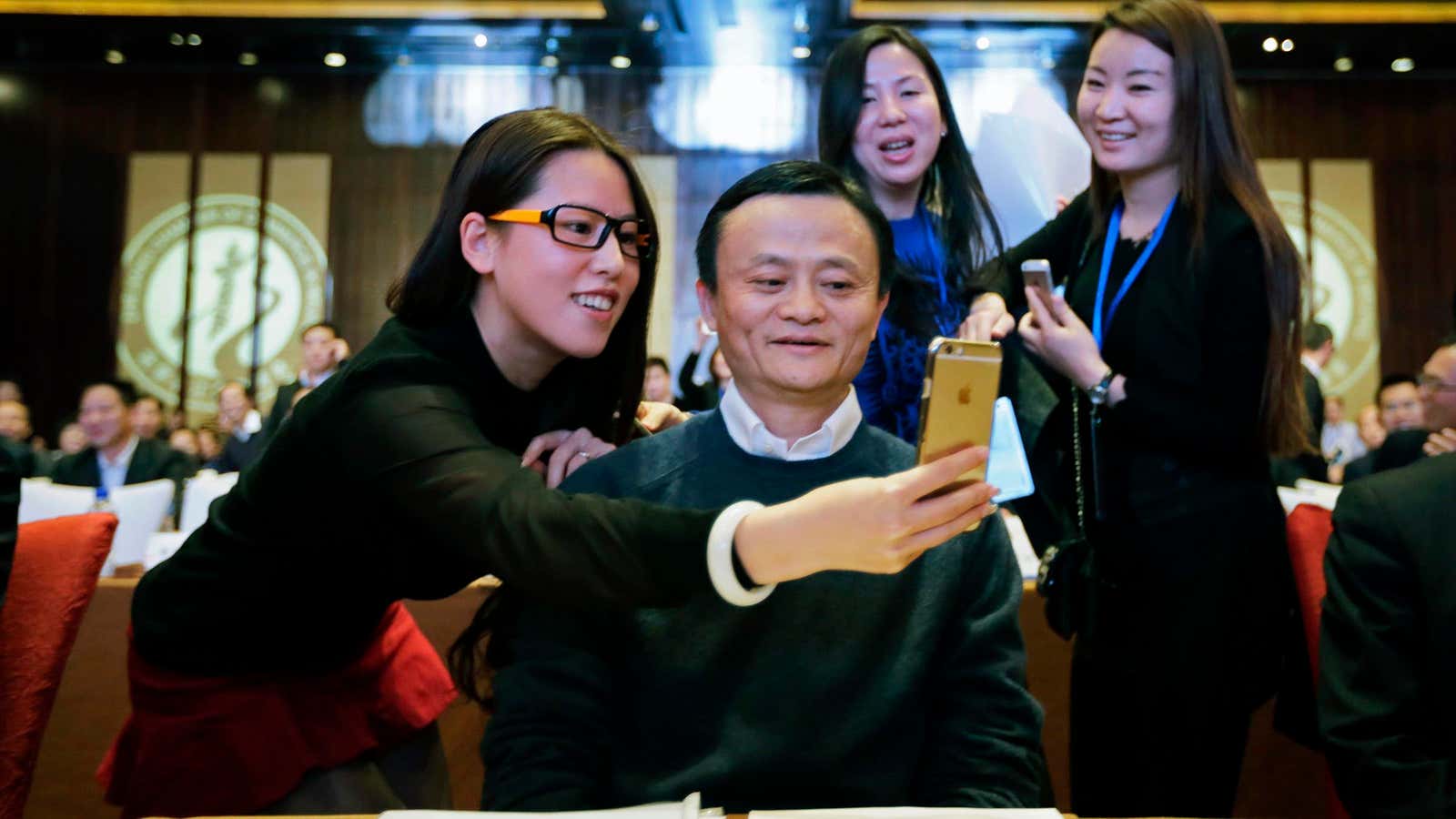 A female delegate takes a “selfie” with Alibaba Group Executive Chairman Jack Ma as he arrives for the Fifth Conference of Zhejiang Chamber of Commerce…