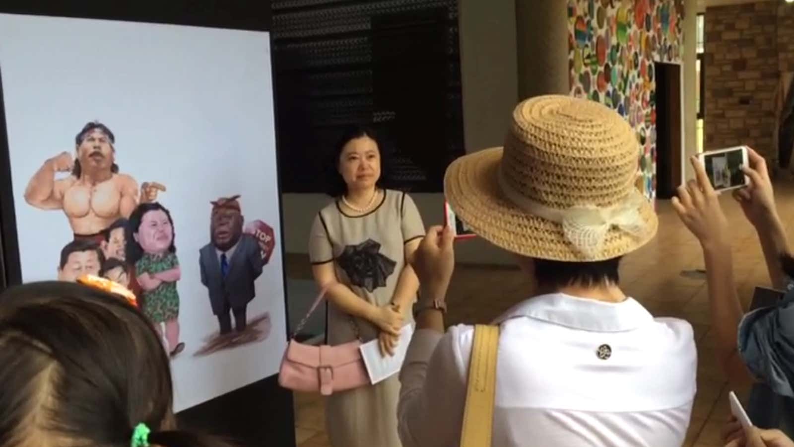 China’s ambassador to Ghana, Sun Baohong, poses with a cartoon criticizing China’s role in Africa.