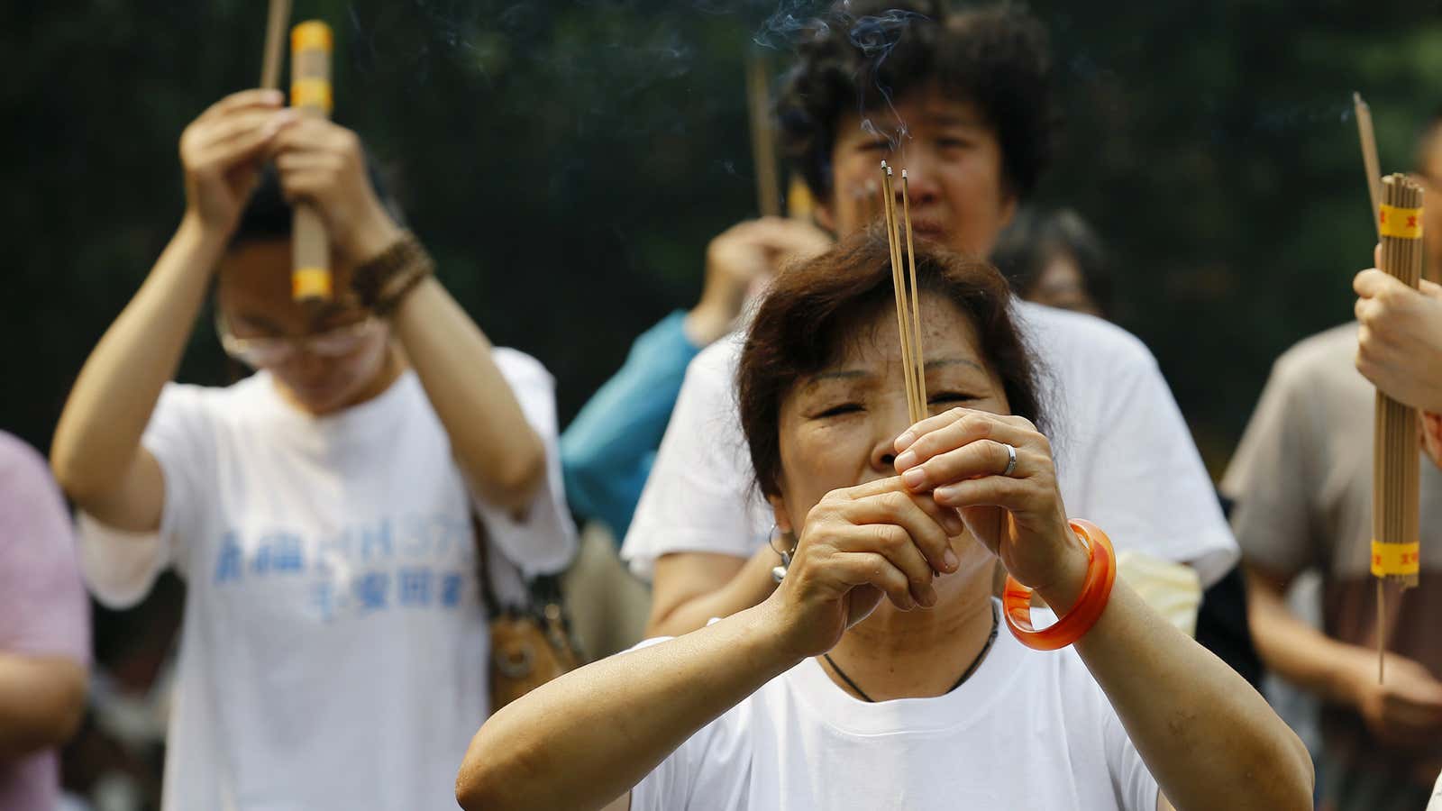 Family members of victims of flight MH370 burn incense in Beijing.