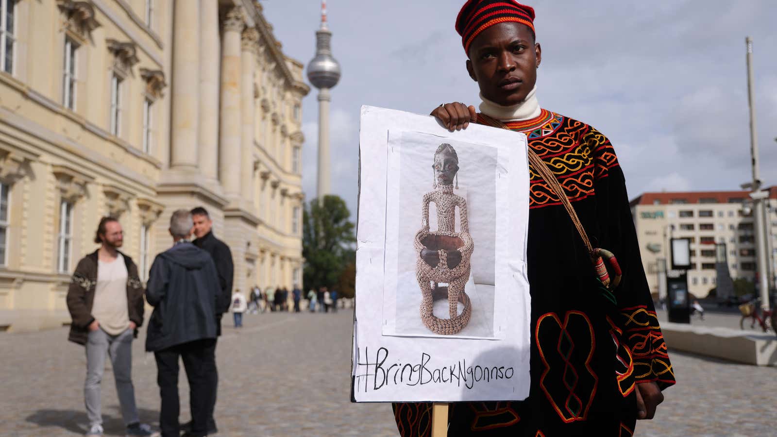 A protester from Cameroon seeking the return of the Ngonnso statue stands outside the Humboldt Forum