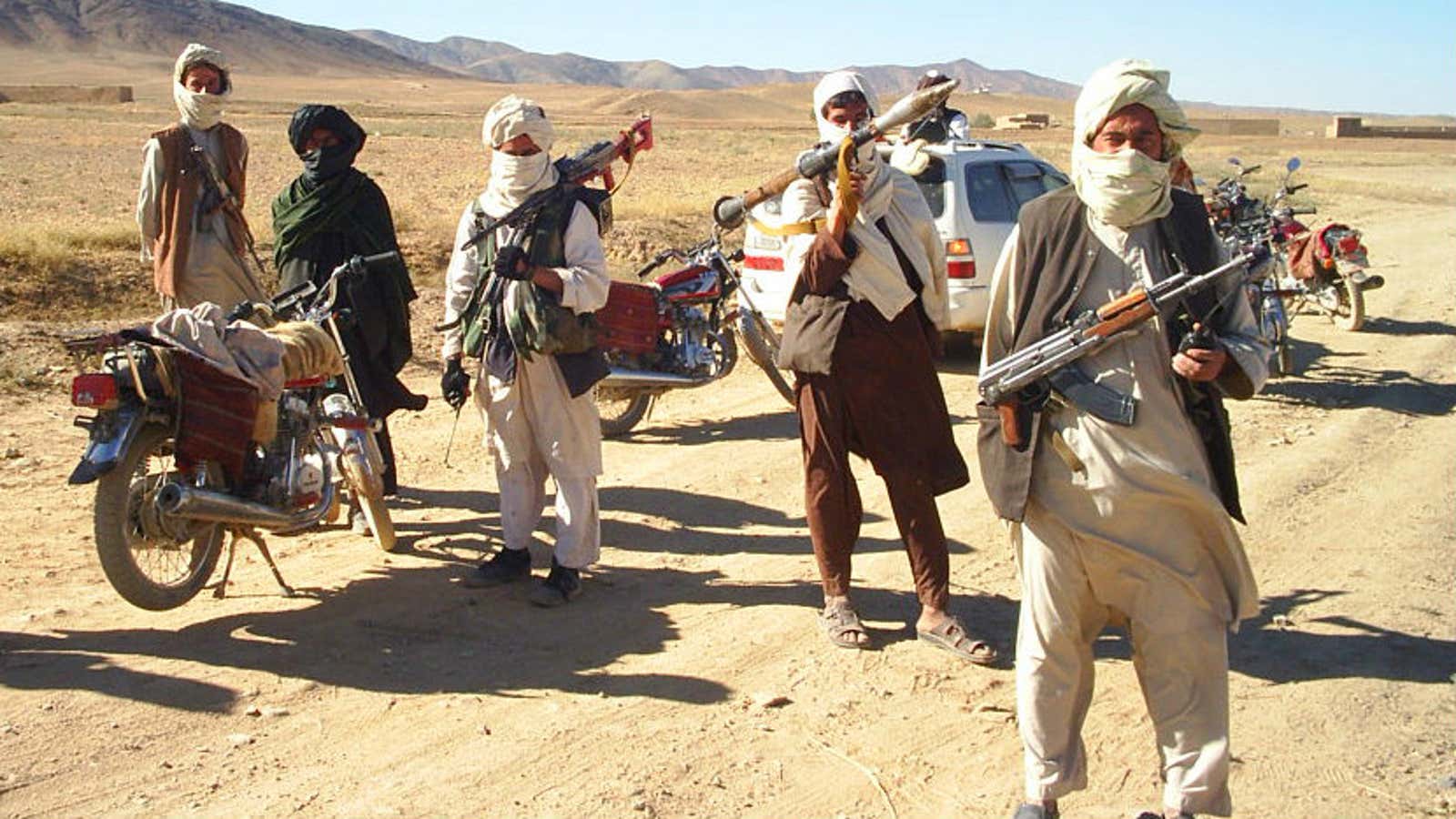 Taliban fighters pose with weapons in Afghanistan.
