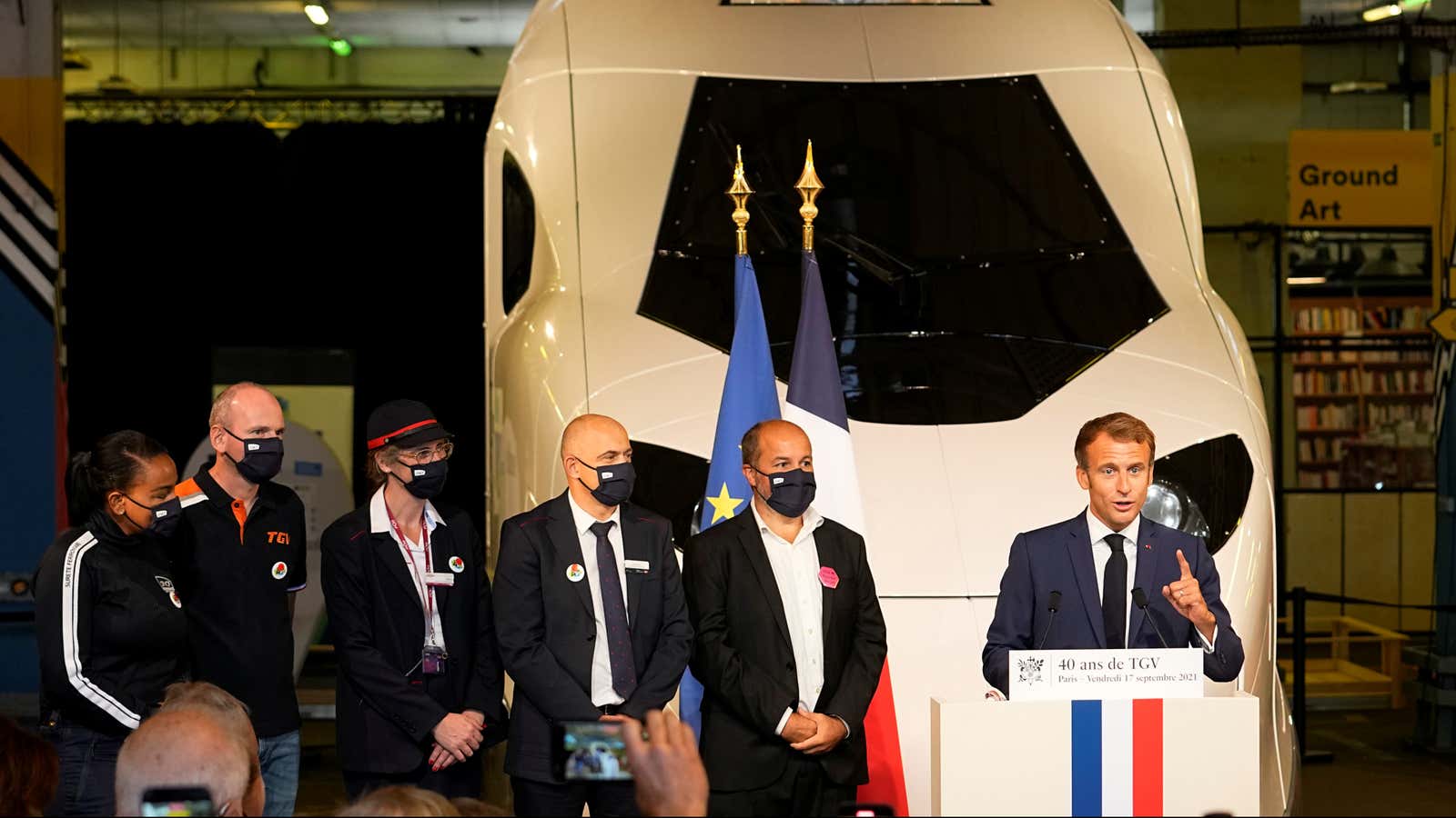 French President Emmanuel Macron speaks in front of a life-size replica of the next high-speed train TGV at the Gare de Lyon station.