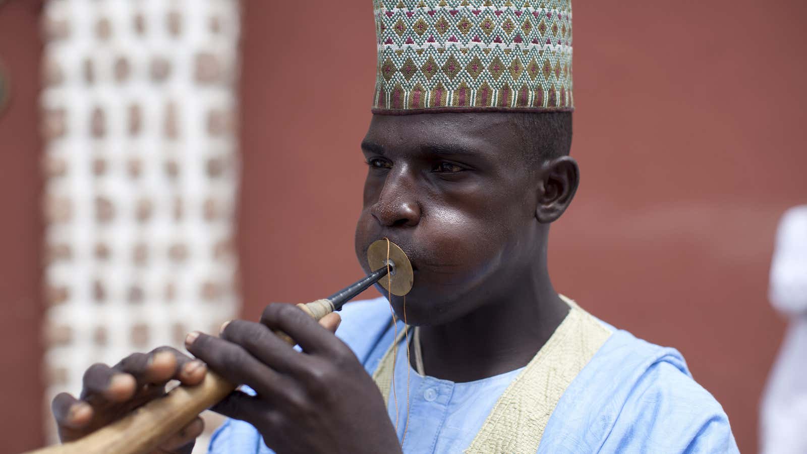 A griot plays a horned instrument at the emir’s palace in Kano, Nigeria