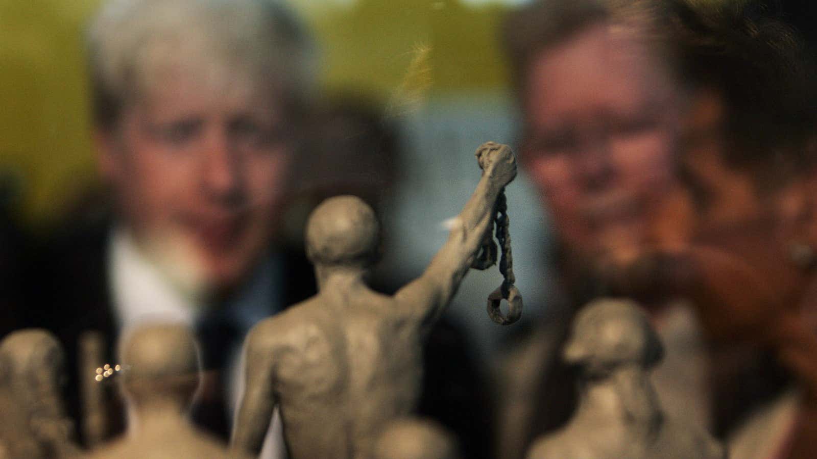 Mayor of London Boris Johnson, left, looks at a model of a statue to be built as a permanent slavery memorial at City Hall in London.