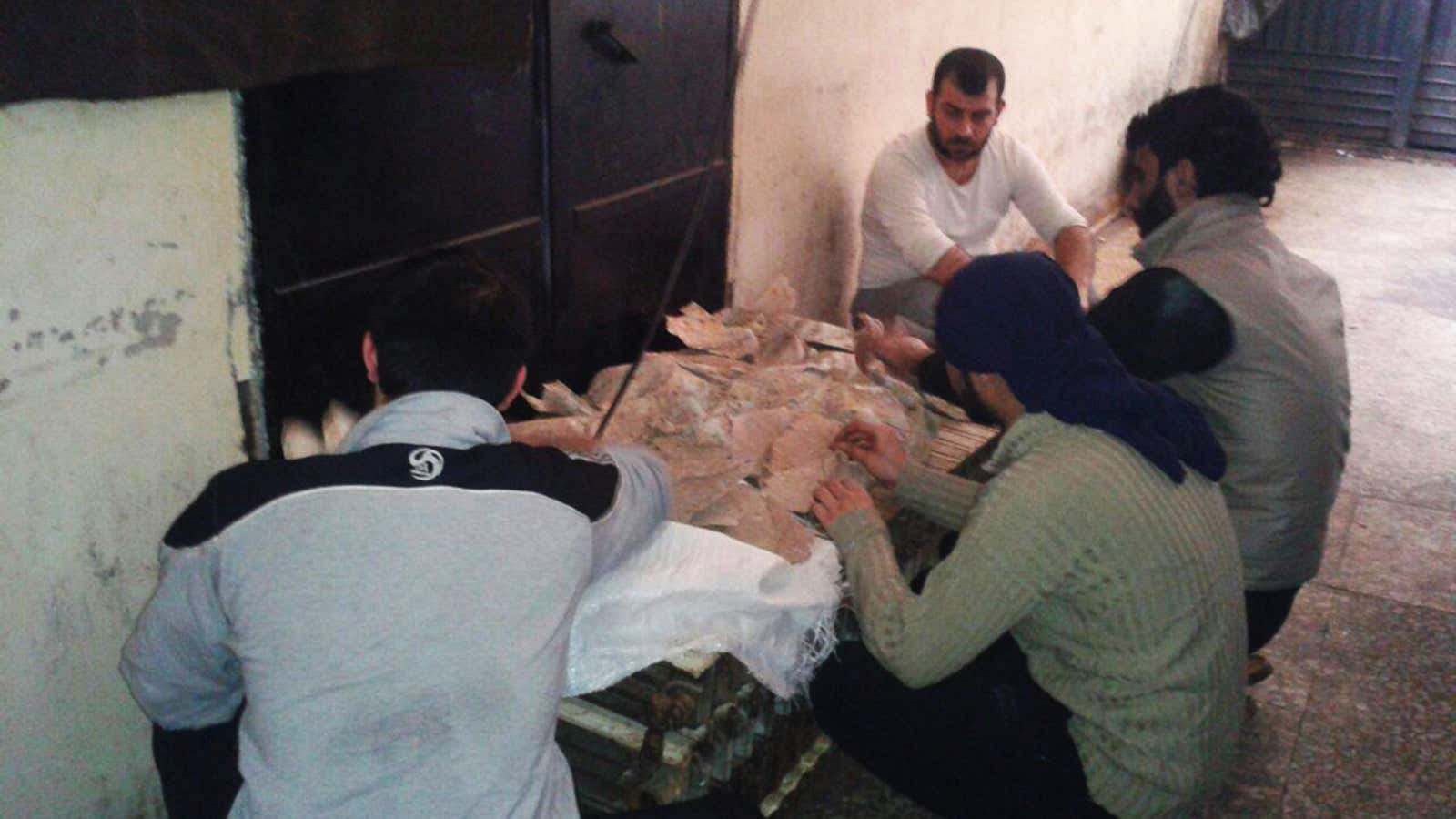 Inmates in Hama Central Prison scrape mold off dry bread, after taking over the prison. Supplies are running low.