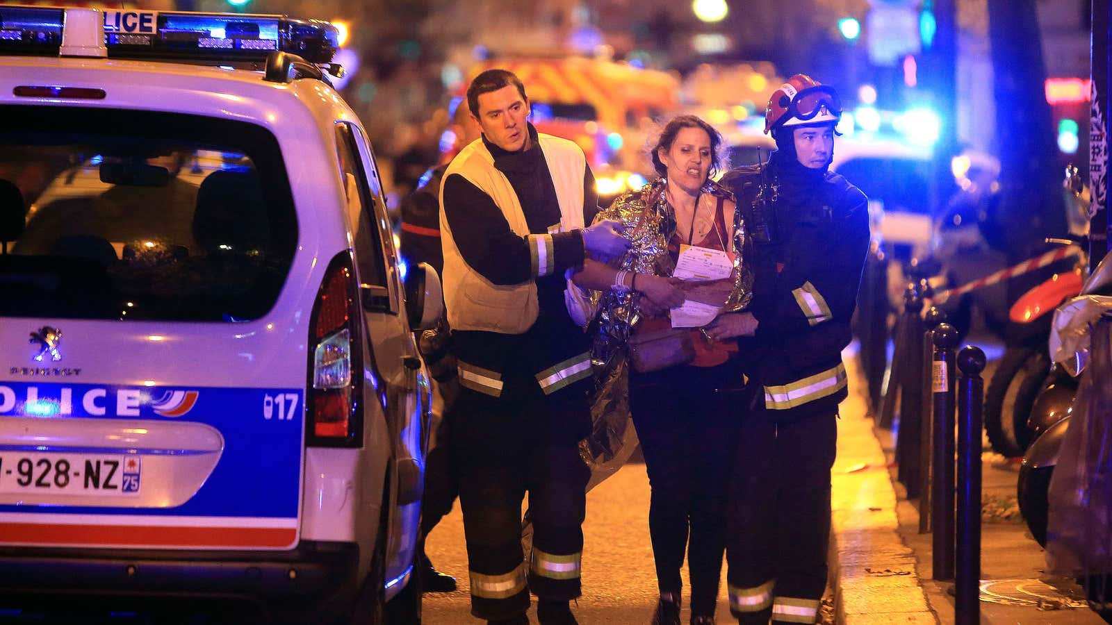 Rescue workers help a woman after an attack outside the Bataclan theater in Paris.