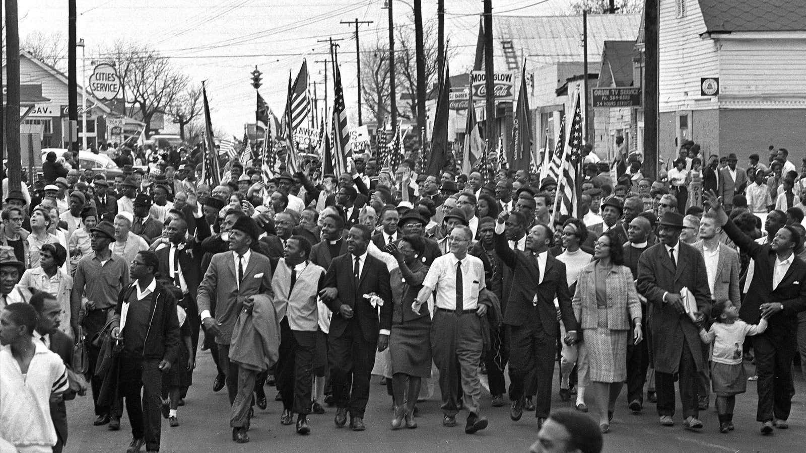 The March 19 civil rights march across the Alabama River, the start of a 50 mile march to Montgomery, Alabama, with Martin Luther King Jr. waving from the front row.