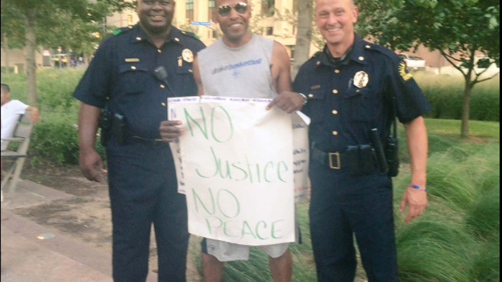 Before the chaos, a photo of peace between two Dallas police officers and a Black Lives Matter protester