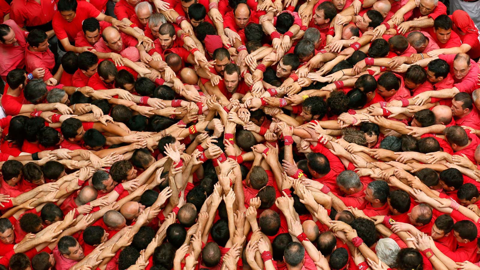 Castellers Colla Joves Xiquets de Valls start to form a human tower called “castells” during the Sant Joan festival at Plaza del Blat square in…