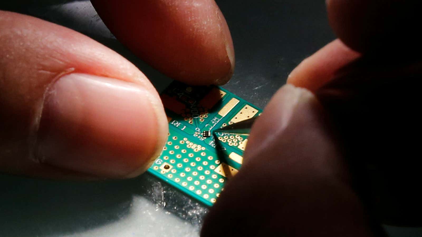 A researcher plants a semiconductor on an interface board during a research work to design and develop a semiconductor product at Tsinghua Unigroup research centre…