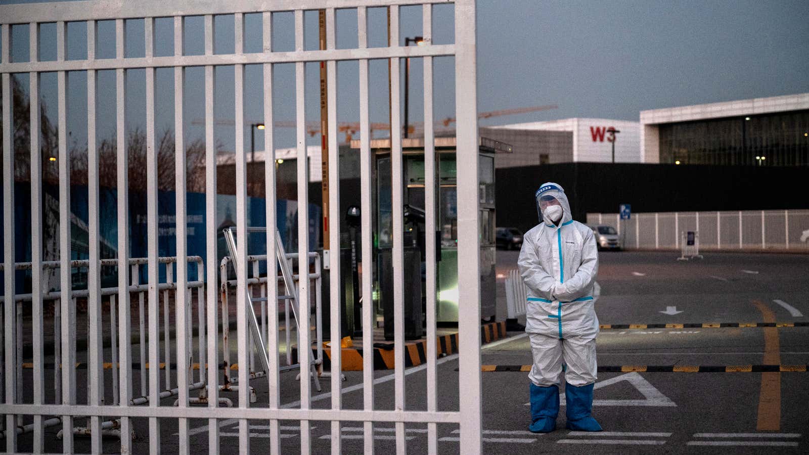 An epidemic control worker wears PPE to protect against the spread of COVID-19 as he guards the gate of a government quarantine facility on December 7, 2022 in Beijing, China.