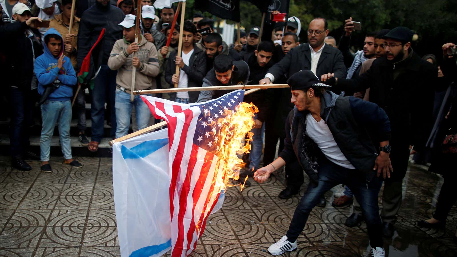 Palestinians burn an Israeli and a U.S. flag while protesting Trump’s decision in Gaza City on Dec. 6.