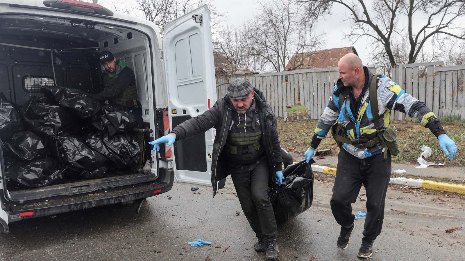 Volunteers in Bucha prepare to put the body of a civilian, who according to residents was killed by Russian soldiers, in a van carrying body bags.