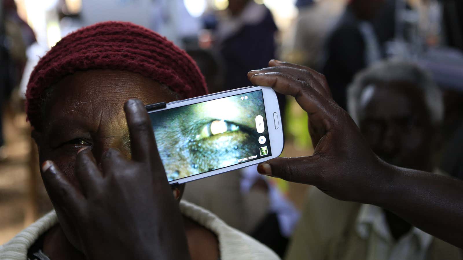 A woman undergoes an eye examination using a smartphone in Kenya