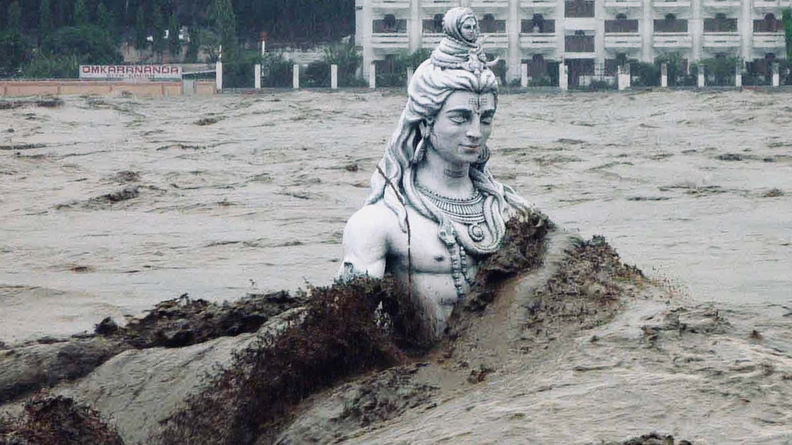 A submerged statue of the Hindu Lord Shiva stands amid the flooded waters of river Ganges.