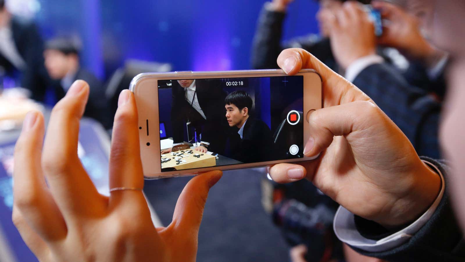 A woman films South Korean professional Go player Lee Sedol after winning the fourth match of the Google DeepMind Challenge Match against Google’s artificial intelligence…