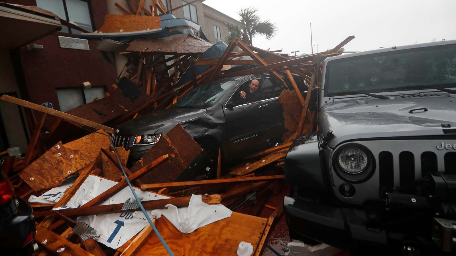 A storm chaser climbs into his vehicle during the eye of Hurricane Michael to retrieve equipment after a hotel canopy collapsed in Panama City Beach, Florida.