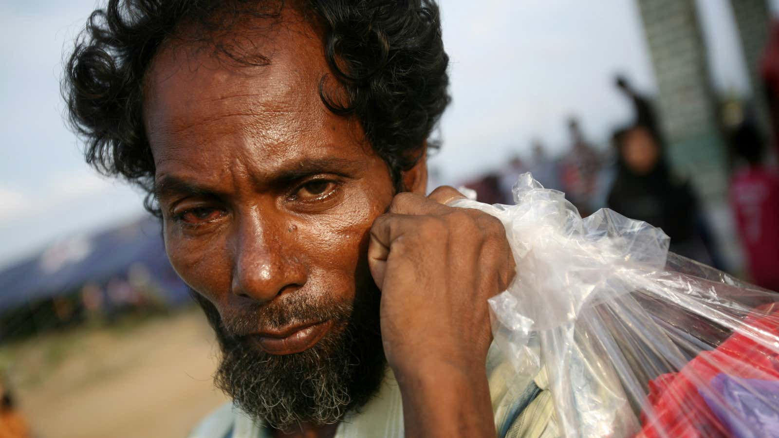 An ethnic Rohingya man carries a plastic bag containing his belongings at a temporary shelter in Lapang, Aceh province, Indonesia.