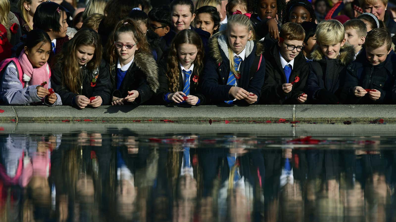 School childern throw poppies into a fountain during an Armistice Day event at Trafalgar Square in London…