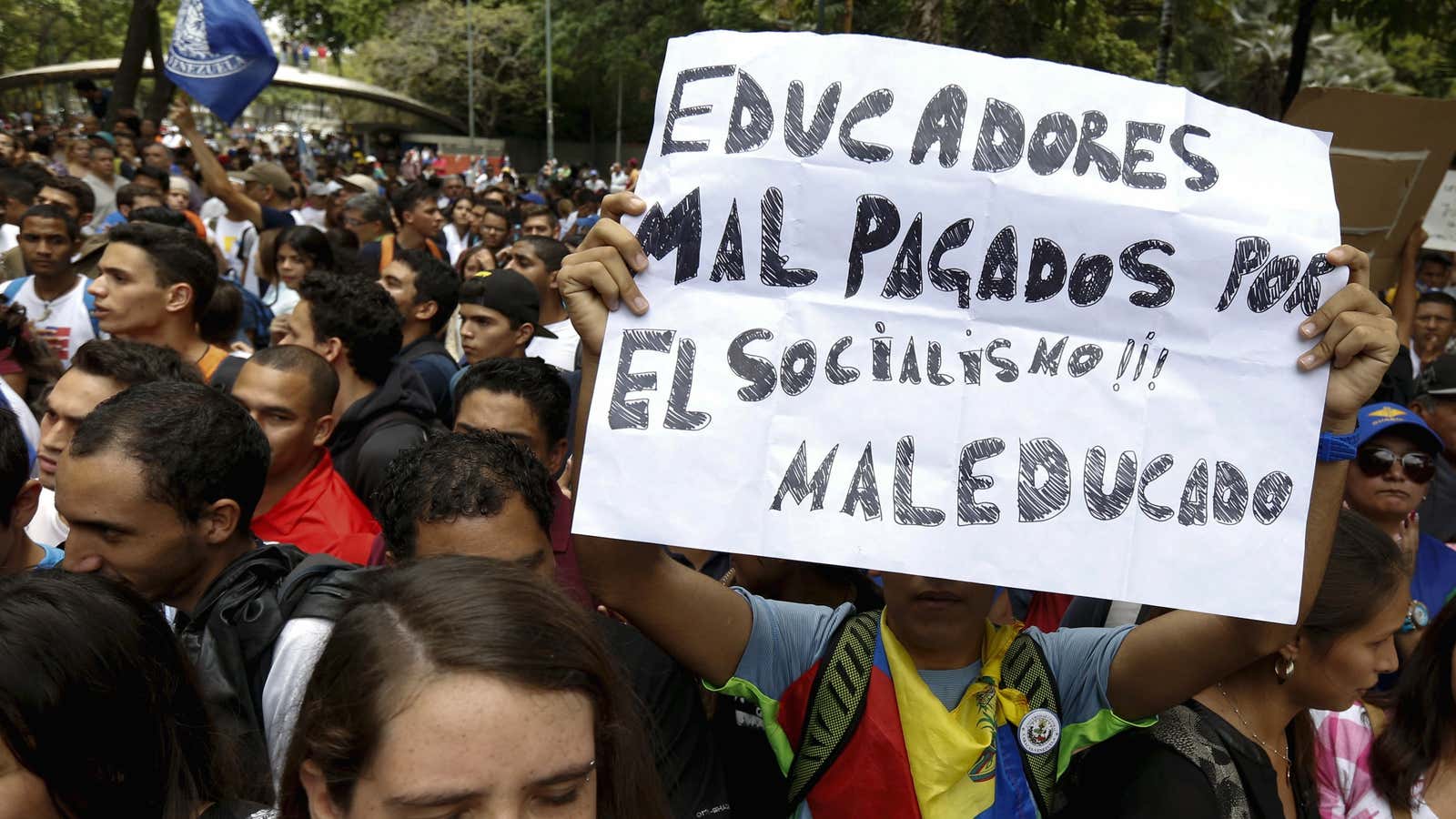 Student protesters and university workers hold a placard that reads, “Underpaid teachers, rude Socialism”, as they take part in a demonstration against insecurity and to request, infrastructure improvements and wage increases, outside Venezuela Central University in Caracas May 28, 2015.