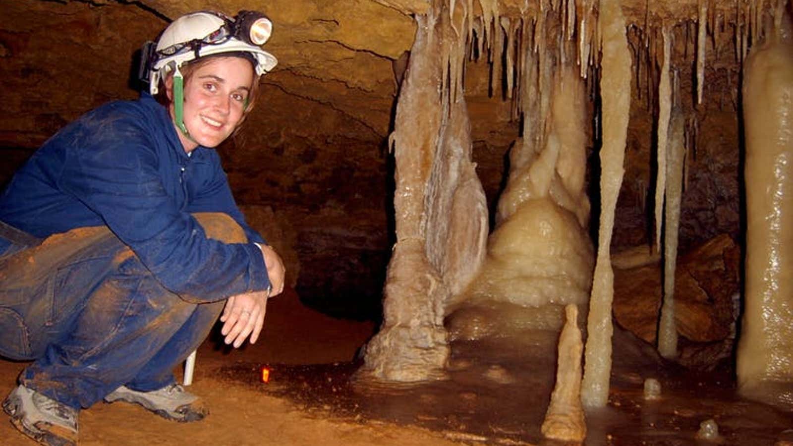 Dr Pickering in a modern cave smiling about the beautiful flowstone on the cave floor.