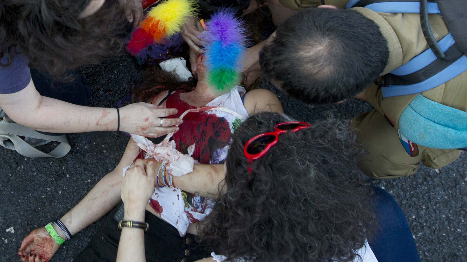 Paramedics help a wounded woman after an ultra-Orthodox Jew attacked people with a knife during a Gay Pride parade.