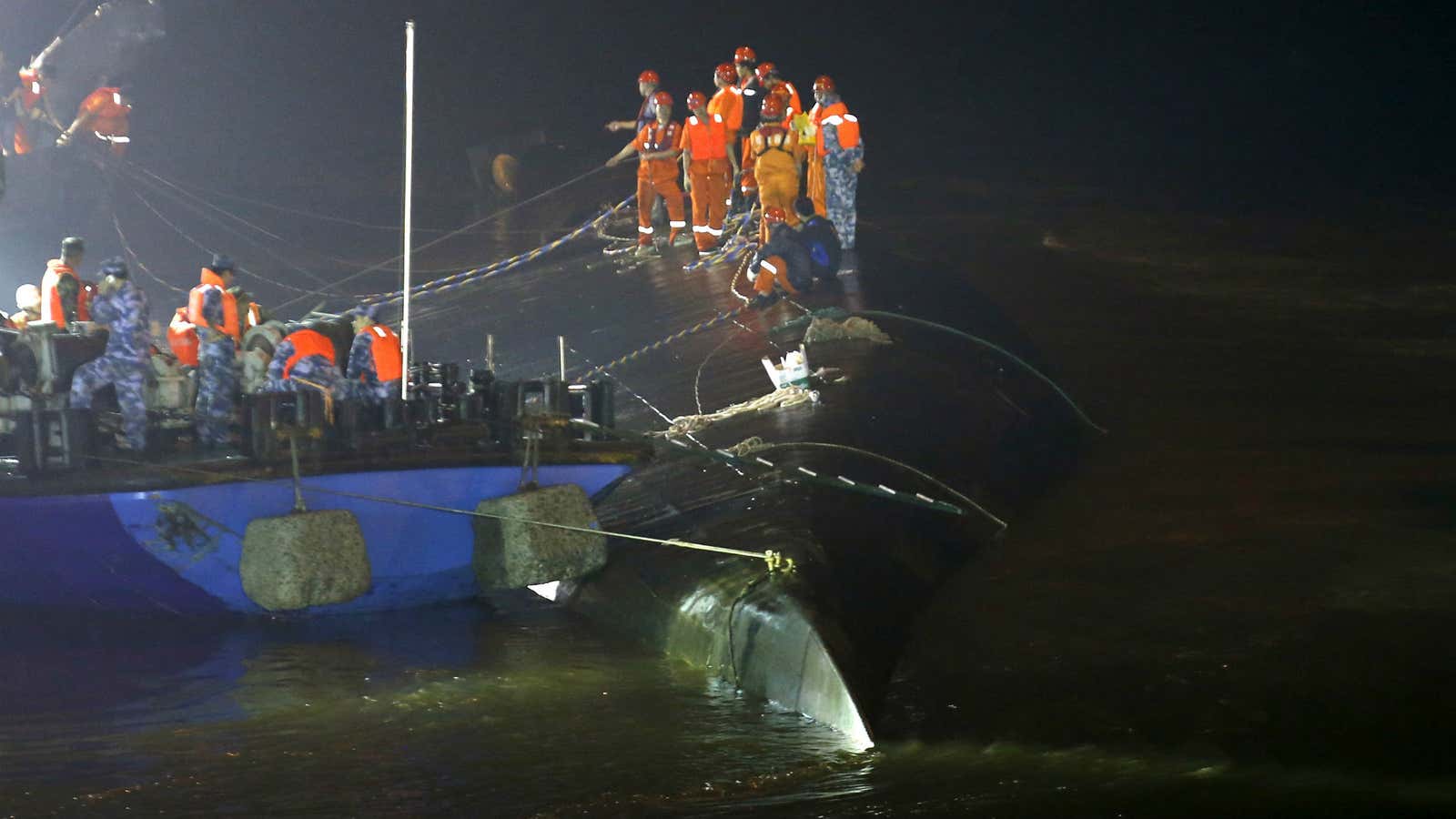 Rescue workers atop the sunken ship in the Yangtze River.