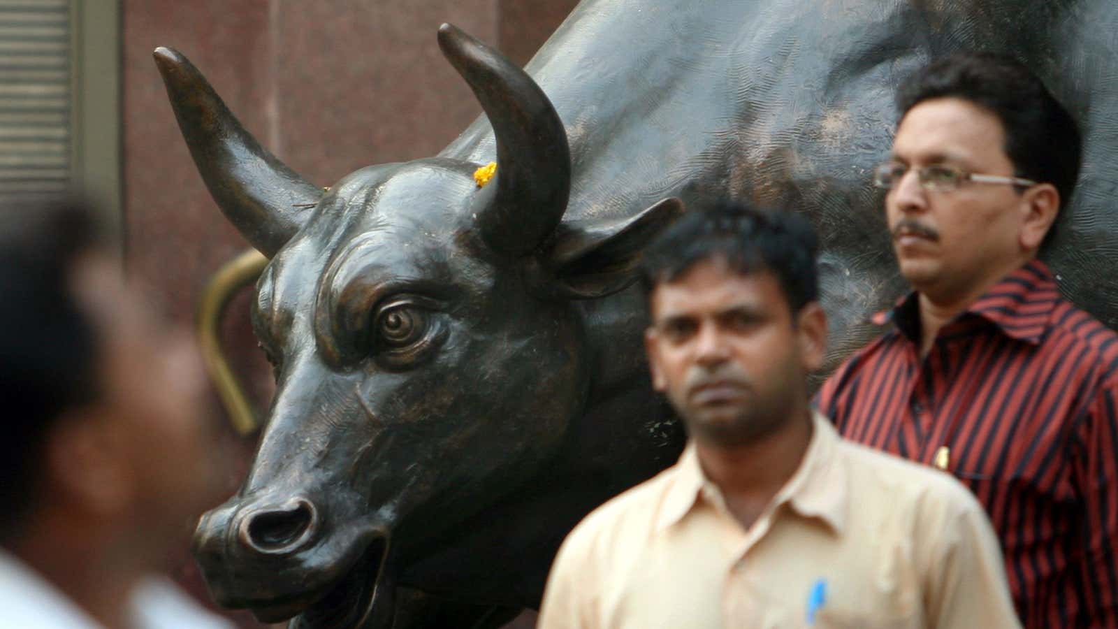 People walk past a bronze replica of a bull at the Bombay Stock Exchange (BSE) building in Mumbai November 3, 2008. The BSE Sensex provisionally…