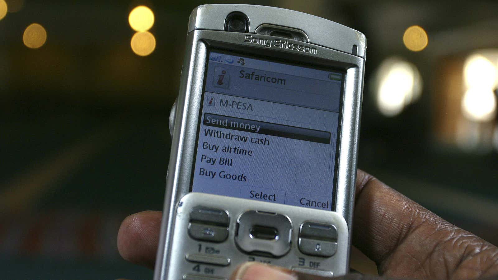 A man scrolls through his mobile phone to carry out a money transaction via M-PESA in Nairobi May 12, 2009.