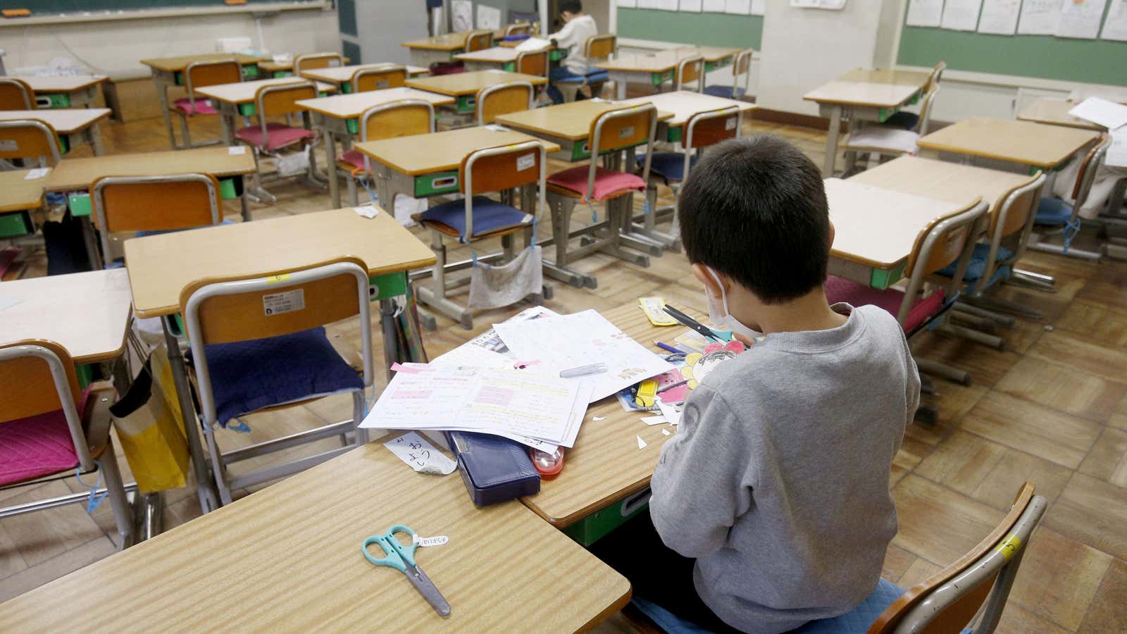 Two students do self-study at an elementary school where the facility was opened for children who cannot stay at home alone while their parents are at work, in Saitama, Japan.