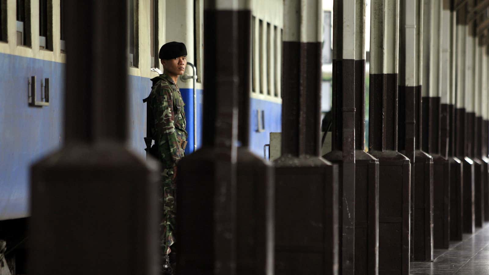 A Thai military guard keeps watch at a train station.
