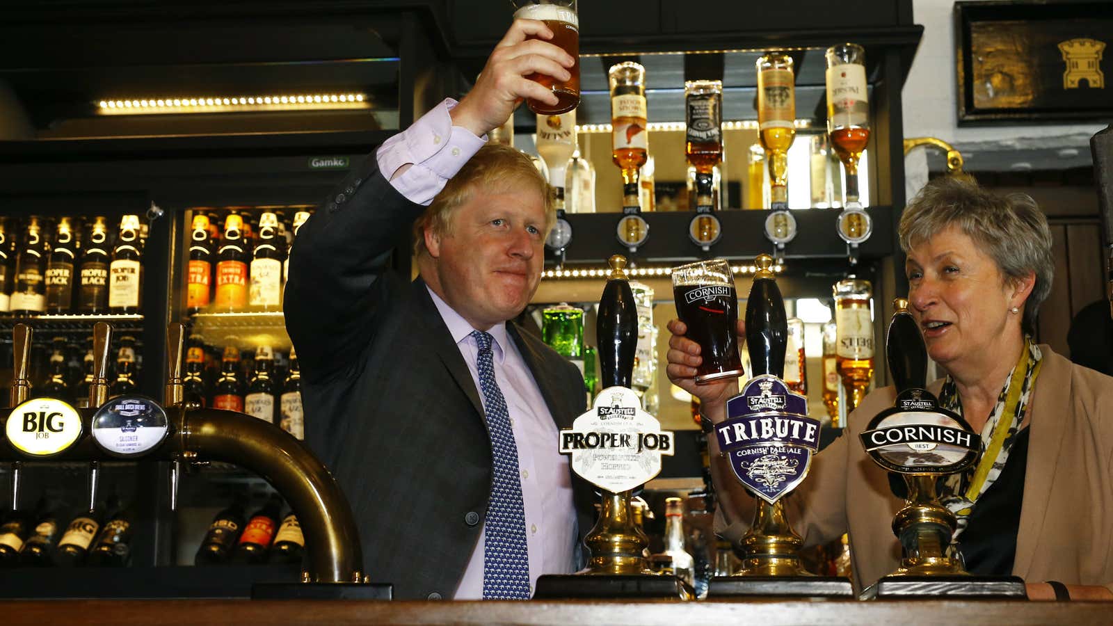Former London Mayor Boris Johnson holds a pint of beer as he stands with MP Gisela Stuart at the St Austell…