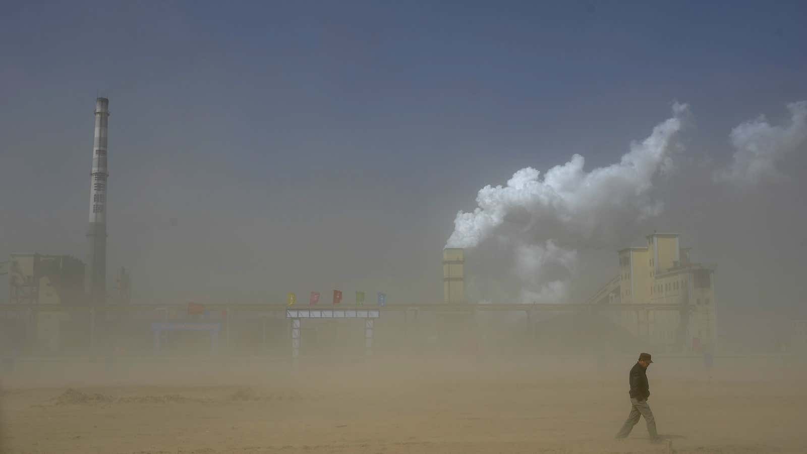 It’s only partly the sand. A man walks past a coal power plant in northern China.