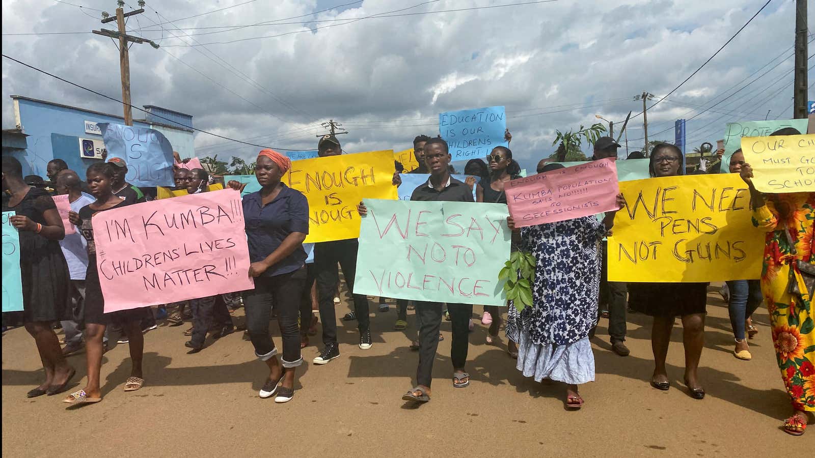 Schoolchildren, their parents and teachers hold a protest after gunmen opened fire at a school in Kumba, Cameroon Oct. 25, 2020.