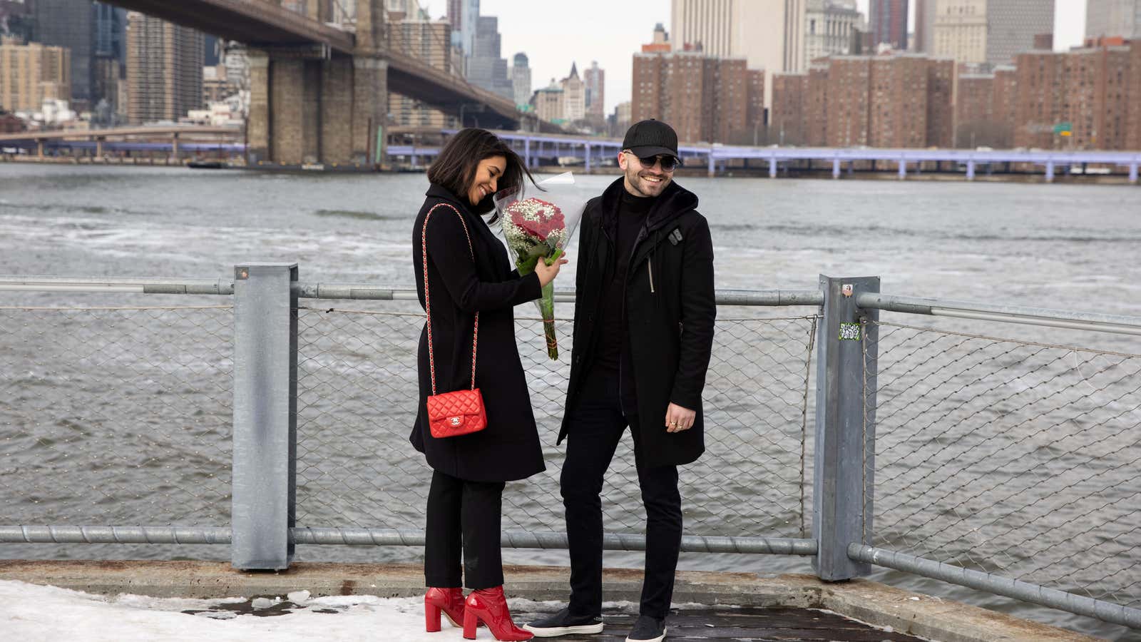 A woman holds roses in front of the Brooklyn Bridge on Valentine’s Day during the coronavirus disease (COVID-19) pandemic, in the Brooklyn borough of New…