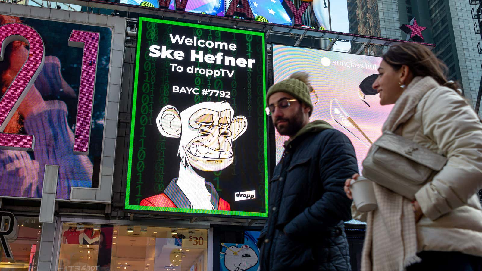 People walk by a Bored Ape Yacht Club NFT billboard in Times Square on January 25, 2022 in New York City.