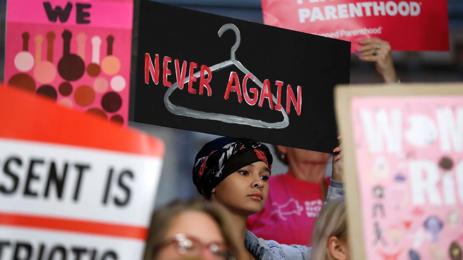 August Mulvihill, of Norwalk, Iowa, center, holds a sign during a rally to protest recent abortion bans on May 21, 2019, at the Statehouse in Des Moines, Iowa.