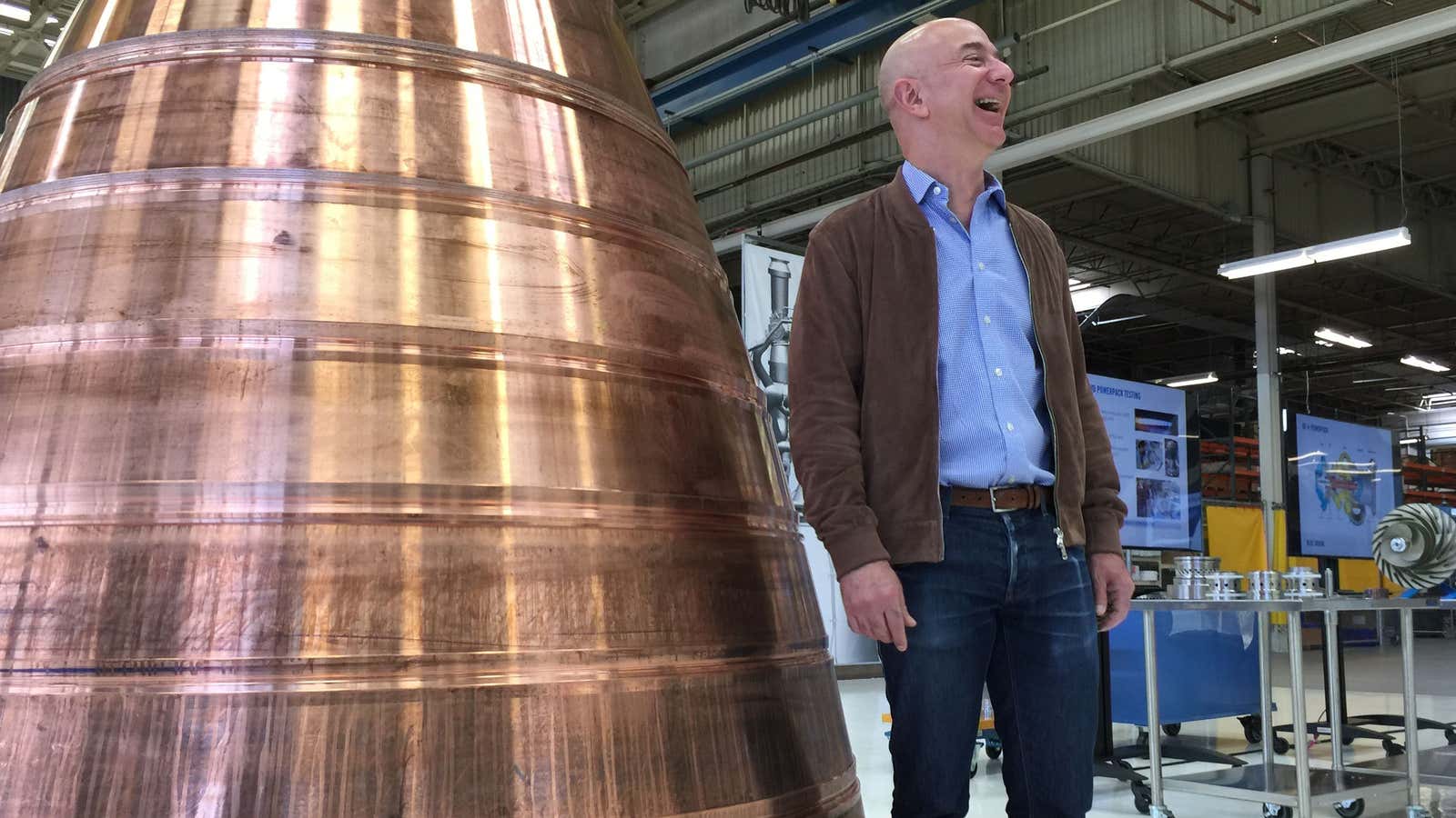 Amazon and Blue Origin founder Jeff Bezos stands next to a copper exhaust nozzle to be used on a space ship engine.
