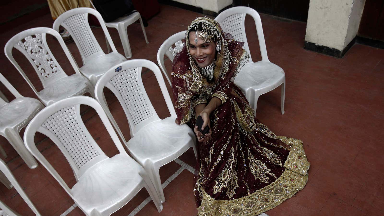 A hijra waits for her dance at a national hijra festival in New Delhi, India.