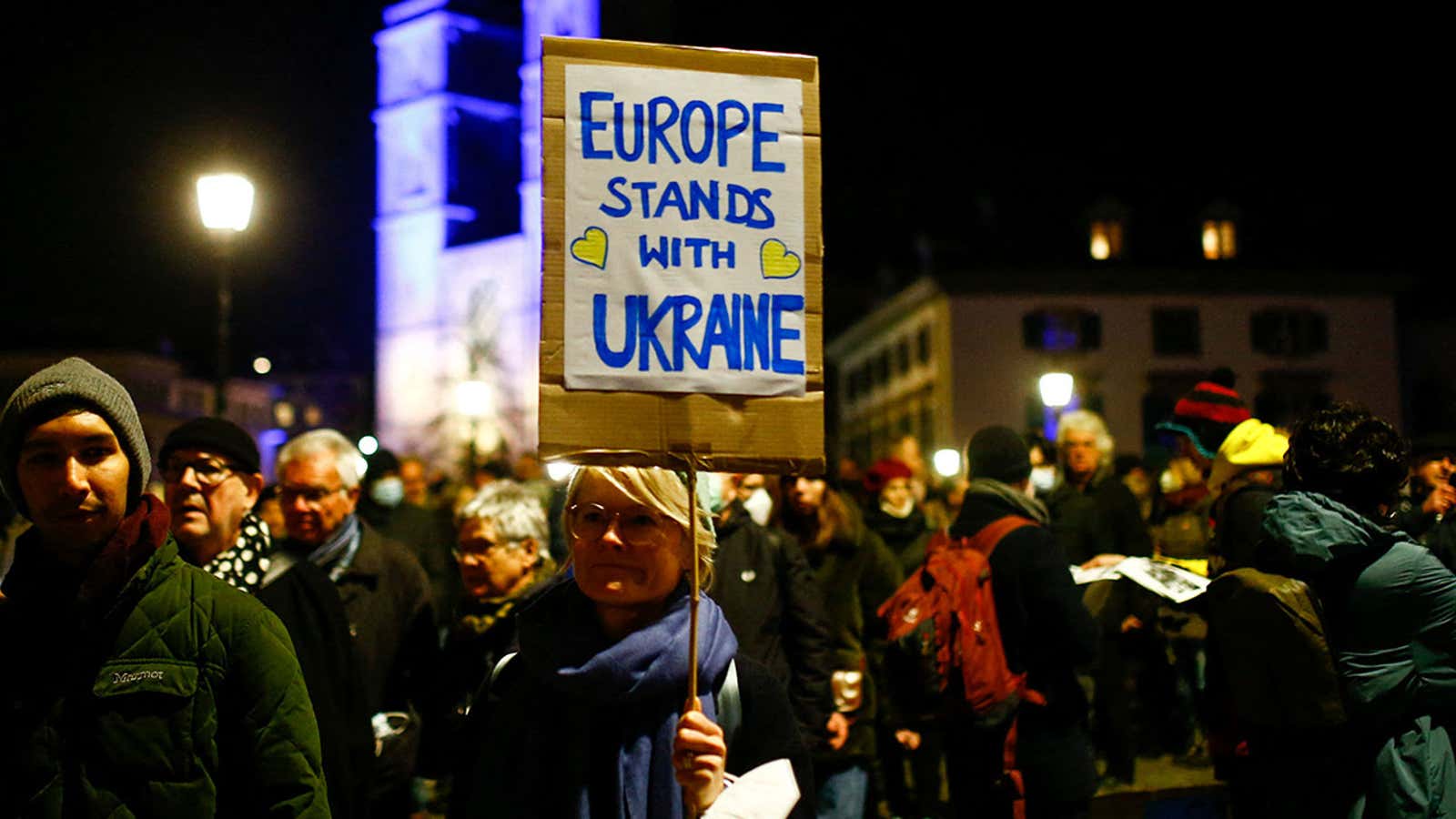 Protestors holding a sign that reads “Europe standing with Ukraine”