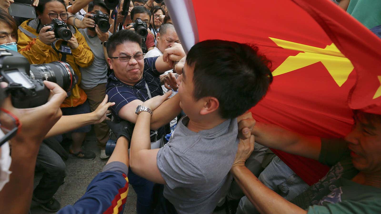 Pro-democracy demonstrators scuffle with a man holding a Chinese flag in Mong Kok.