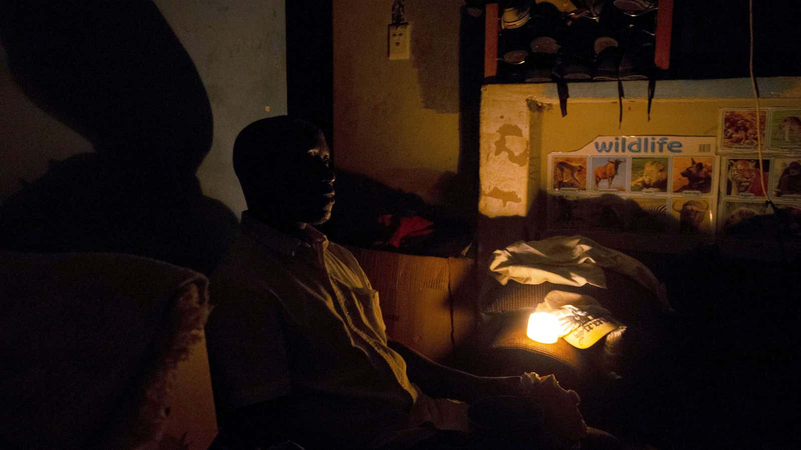 A man uses candle light during load shedding in Embo, South Africa