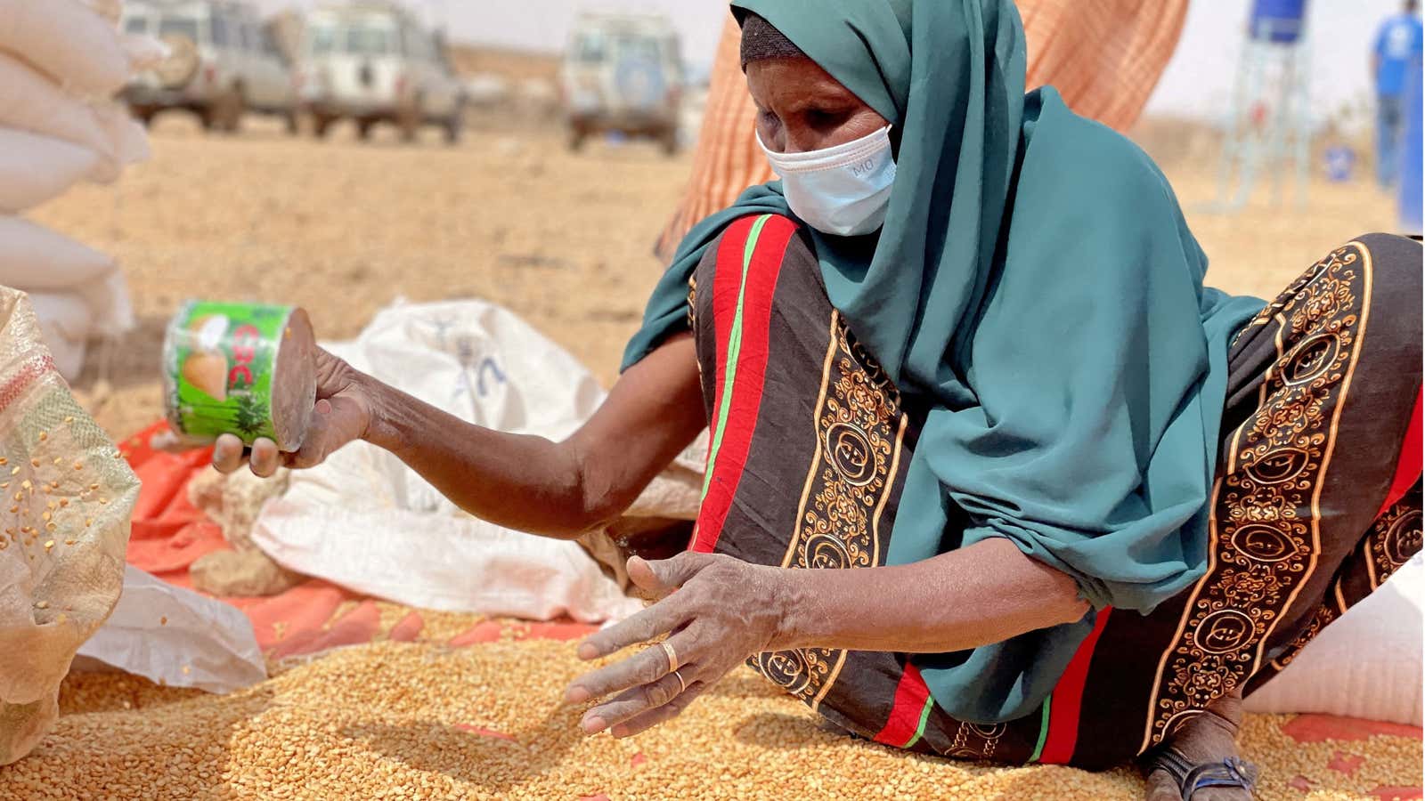 A woman collects grain at a camp for IDPs in the Somali region, Ethiopia.