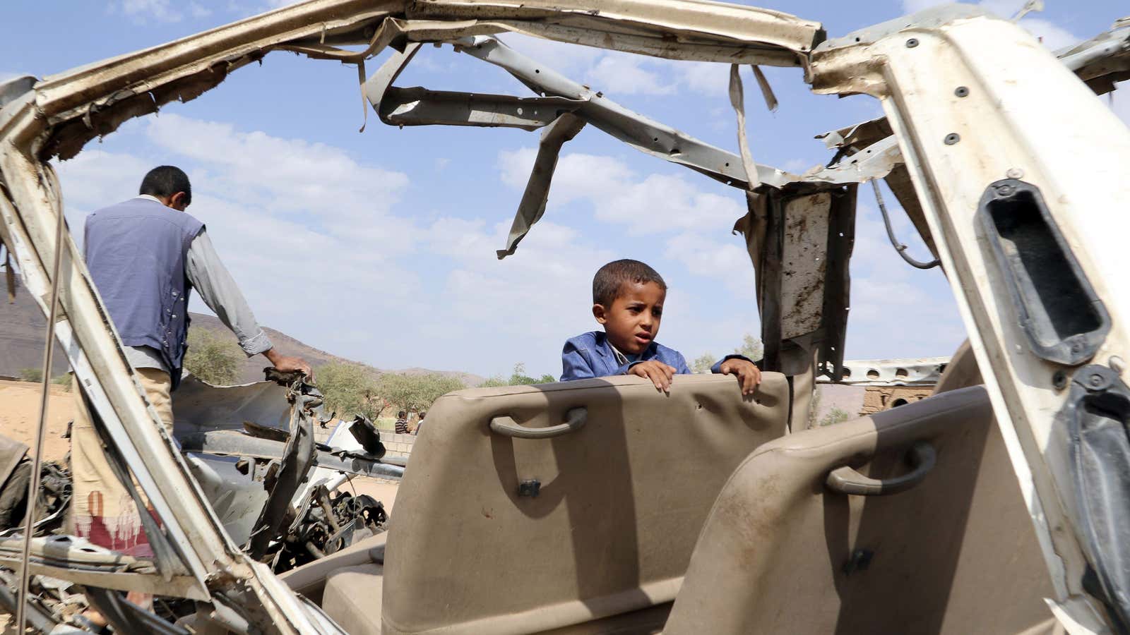 A boy in Yemen looks over the wreckage of a Saudi air strike that killed his brother; September 2018.