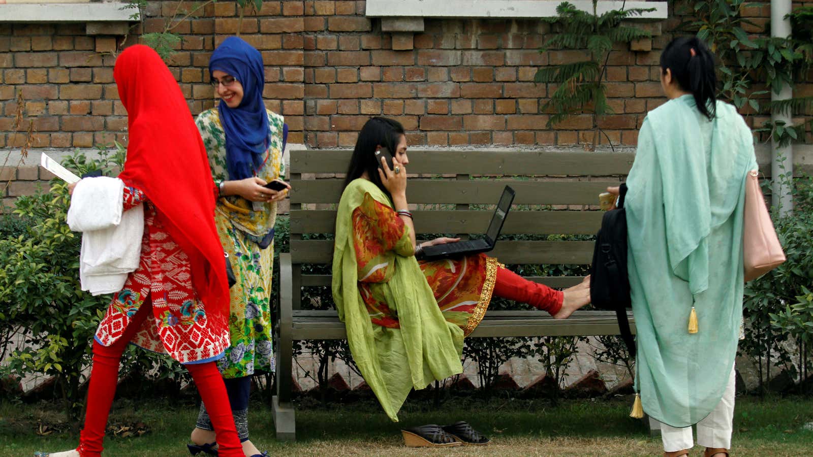 A student works on her computer sitting on a bench at Shaheed Benazir Bhutto Women’s University in Peshawar.